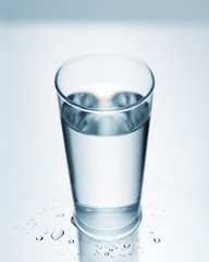 Background image of one selective focus glass filled with pure cold water.