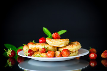 fried sweet pancakes with ripe strawberries in a plate