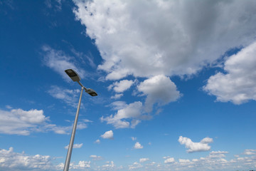 Strassenlampe vor blauem Sommerhimmel mit Wolken