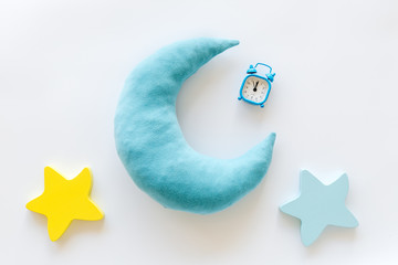 Night sleep concept with moon, stars toy and alarm clock on white background top view