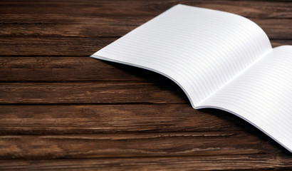 Open notebook on a brown wooden surface. Back to school. Office tool. Place for text. Education.