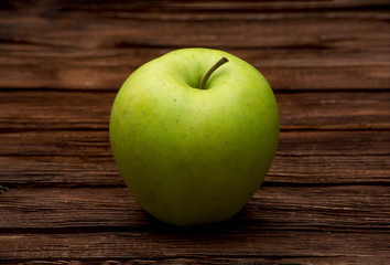 Green apple on dark brown wooden background. Summer fruits. Natural vitamins. Healthy food.