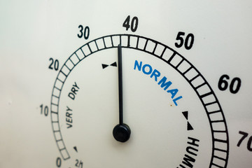 Humidity and weather conditions concept. Face of analog humidity indicator instrument with needle. Normal range is indicated. Humidor or cigar keeping closeup image