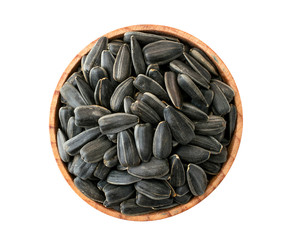Roasted sunflower seeds in wooden plate on a white. The view of the top.
