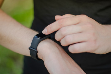 A young girl uses a fitness tracker. Smartwatch.