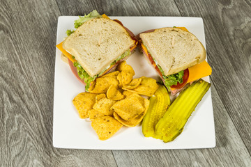 Overhead View of Bologna and Cheese Sandwich with Chips and Pickles