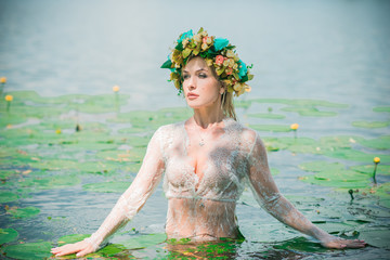 A fabulous, lake nymph in long white lace dress and wreath. Artistic Photography, Mysterious scene....
