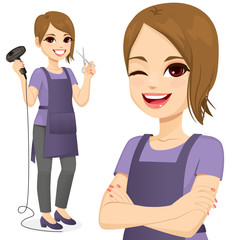 Hairdresser woman standing holding hairdryer and scissors and with arms crossed winking