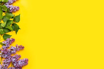 Decorative frame of lilac flowers and space for text. yellow background