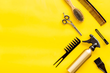 professional accessories of hairdresser with combs and sciccors on work desk yellow background top...