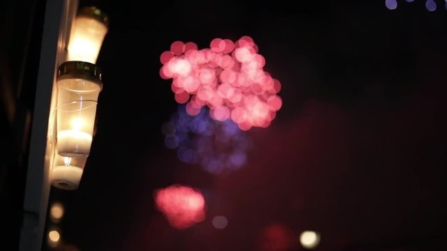 Fuochi d'artificio sfuocati in citt&agrave; con lumini e fiaccole accesi