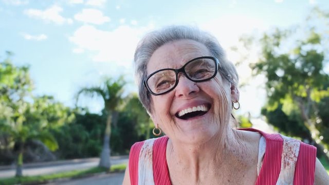 Smiling old woman. Beautiful senior woman looking at the camera with a warm friendly smile and attentive expression. Elderly woman laughing.