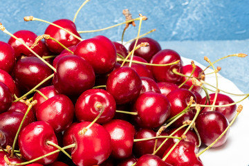 ripe red cherries on a white plate