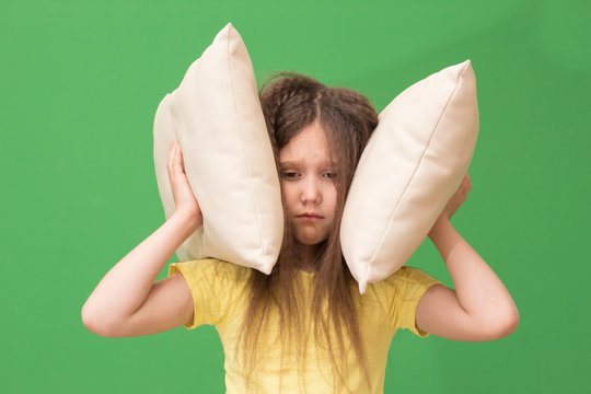 Child Covers The Ears With Pillows, The Girl Suffers From Insomnia