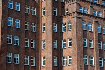Fototapeta premium Lots of windows on the front of an old house with red brickwalls in an inner city in germany in summer