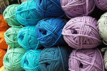 Many multicolored balls of wool yarn in piles, Iridescent dyeing...