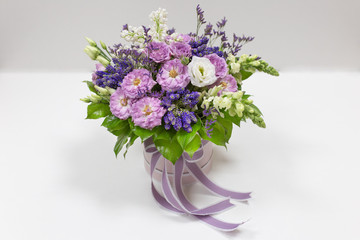 Exquisite bouquet of Roses, Eustoma, Veronica, Snapdragon and Lilac (white, lilac, green blue, lime, purple) in a small gift cardboard box on a light background