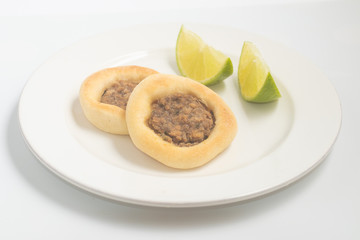 Arabic Meat sfiha over a wooden table.