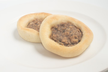 Arabic Meat sfiha over a wooden table.