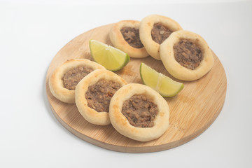 Arabic Meat sfiha over a wooden table.