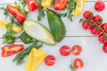Fresh organic vegetables, cherry tomatoes, avocado, cucumbers, carrot, red and yellow pepper, green. Vegan food, healthy lifestyle concept