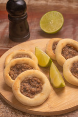 Arabic Meat sfiha over a wooden table.