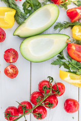 Fresh organic vegetables, cherry tomatoes, avocado, cucumbers, carrot, red and yellow pepper, green. Vegan food, healthy lifestyle concept