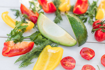 Fresh organic vegetables, cherry tomatoes, avocado, cucumbers, carrot, red and yellow pepper, green. Vegan food, healthy lifestyle concept