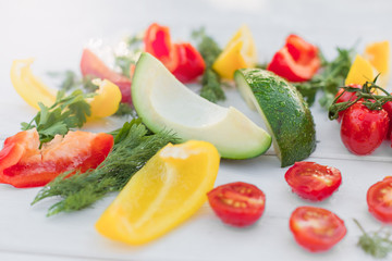 Fresh organic vegetables, cherry tomatoes, avocado, cucumbers, carrot, red and yellow pepper, green. Vegan food, healthy lifestyle concept