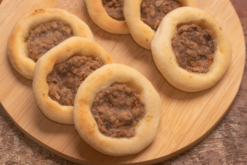 Arabic Meat sfiha over a wooden table.