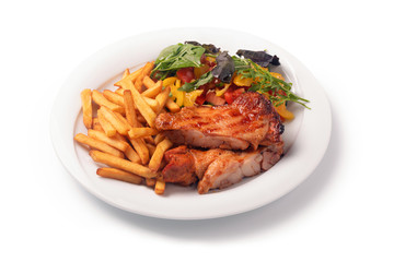Chicken schnitzel, served with fries and salad on a plate, isolated on white background