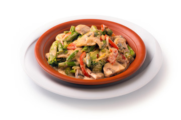 Stewed meat with vegetables and mushrooms in sour cream sauce, isolated on white background