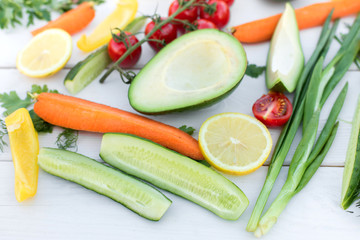 Fresh organic vegetables, cherry tomatoes, avocado, cucumbers, carrot, red and yellow pepper, green. Vegan food, healthy lifestyle concept