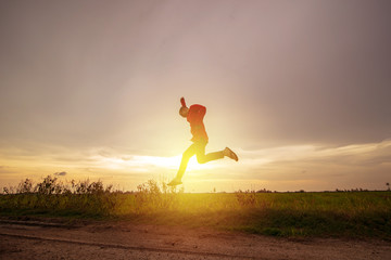 Young man jump over paddy field meadow with sunset scenic, freedom, escape concept, copy space.