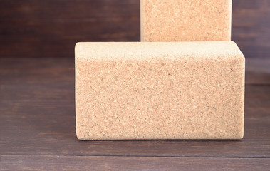 Two cork blocks for doing yoga on wooden floor. Yoga props background.