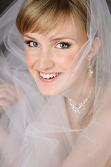 Young beautiful happy smiling bride with fancy makeup and bridal veil