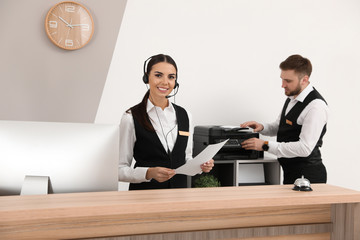 Young receptionists in professional uniform at workplace