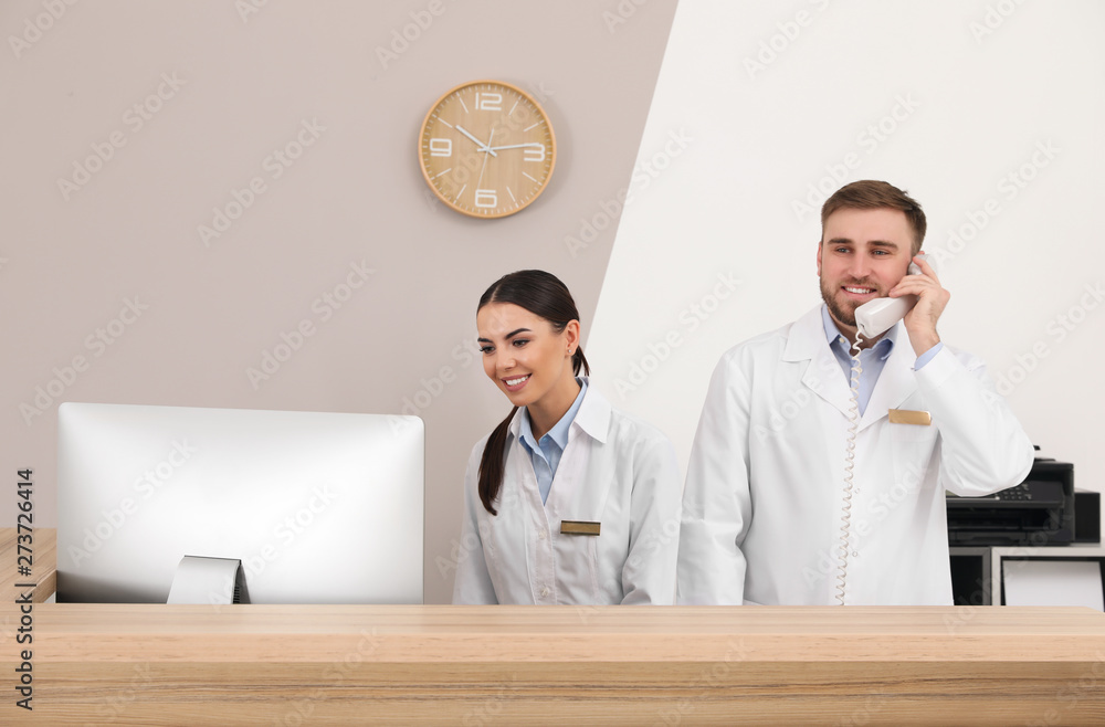 Wall mural Professional staff working at reception in modern clinic