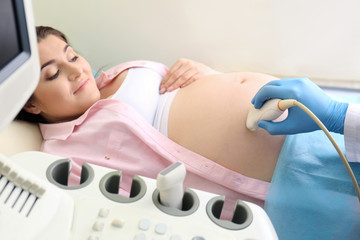 Obraz premium Young pregnant woman undergoing ultrasound scan in clinic