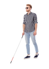 Young blind person with long cane walking on white background