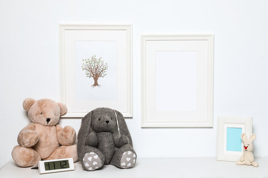 Composition with soft toys and photo frame on white background. Child room interior decor