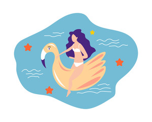 Girl in a swimsuit sits on an inflatable  flamingo in the pool. Summer concept.