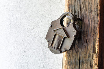 Vintage padlock on a old wooden door. Interesting old padlock on a wooden medieval door.