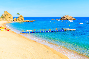 Azure blue water on idyllic beach in Tossa de Mar town, Costa Brava, Spain