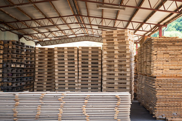 Sawmill factory warehouse with pile of palettes and wood material planks.