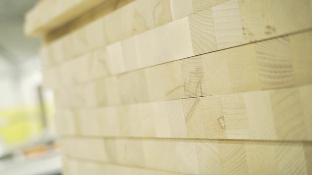 Close-up of wooden wall texture with squares. Action. Light stacks of square wooden cubes making up wall. Wood coating samples