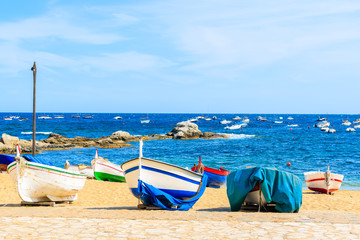 Traditional fishing boat on beach in Calella de Palafrugell, scenic village with white houses and sandy beach with clear blue water, Costa Brava, Catalonia, Spain