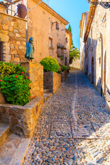 Fototapeta na wymiar Narrow street with stone houses in old town in Tossa de Mar, Costa Brava, Spain
