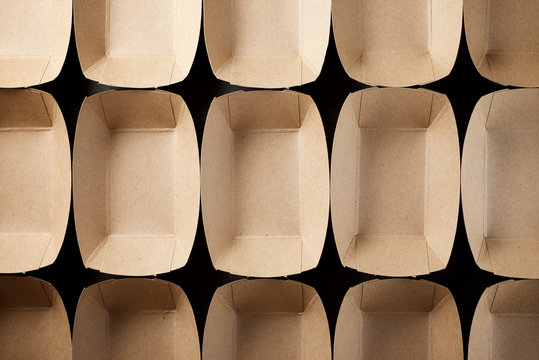 Empty boxes of disposable cardboard to distribute snacks on a black table.