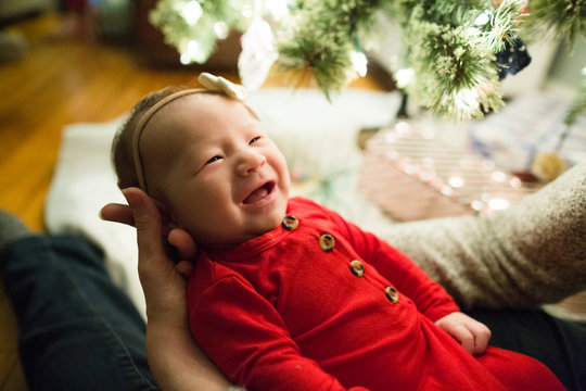 Smiling Baby Girl Looks Up At Mother During Christmas Celebration